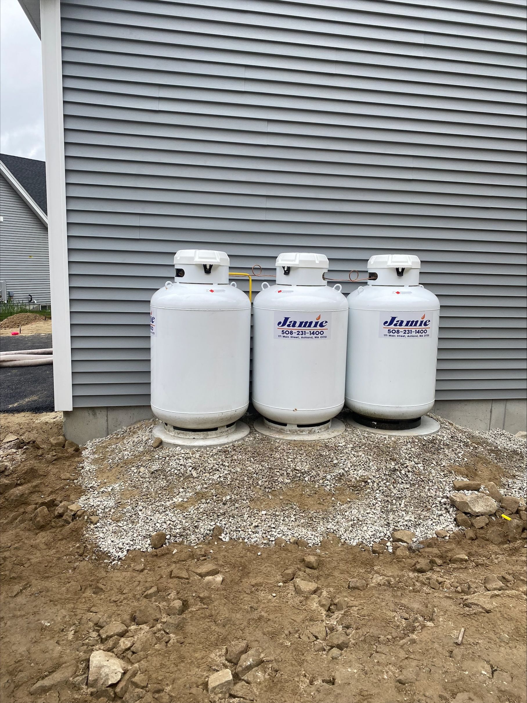 Truck transporting blue propane tanks on a highway for residential propane supplier delivery.