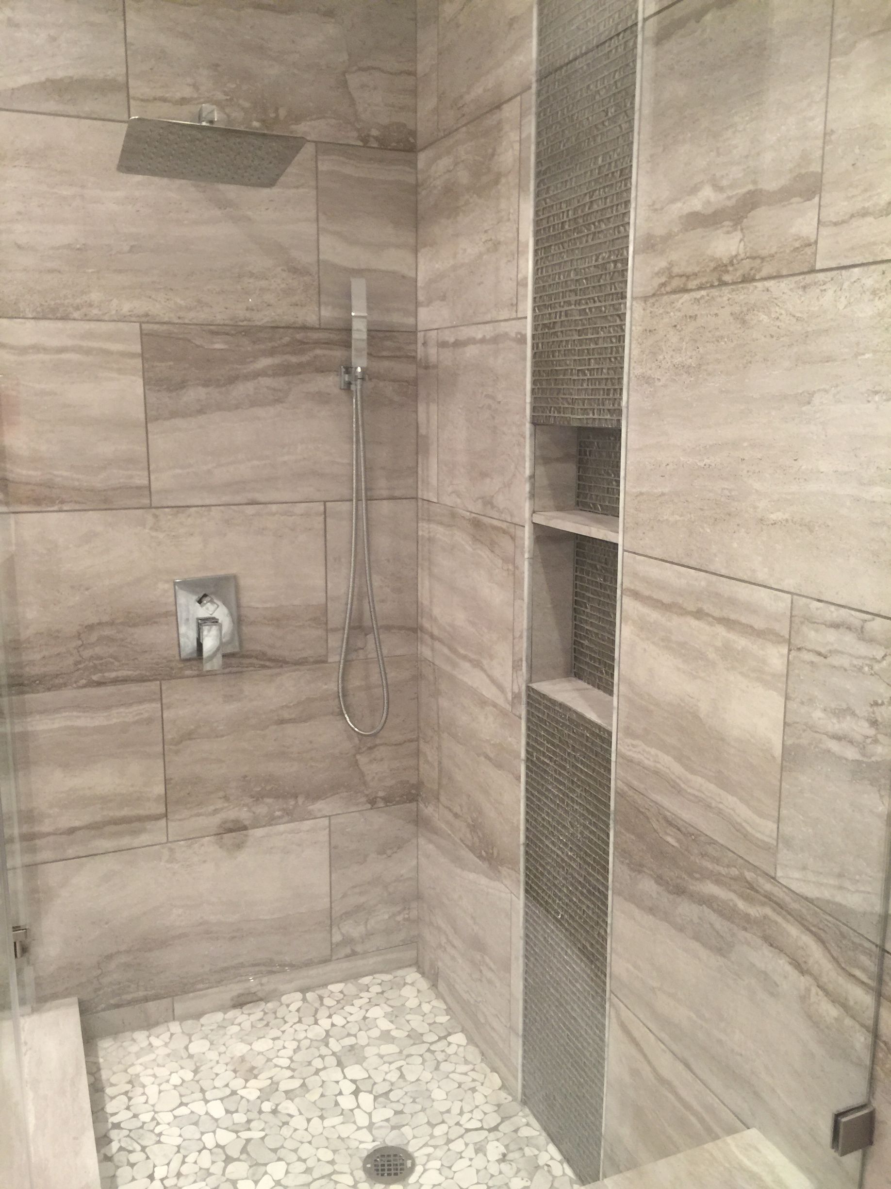 Modern tiled shower with rain head, wall controls, and built-in corner shelves