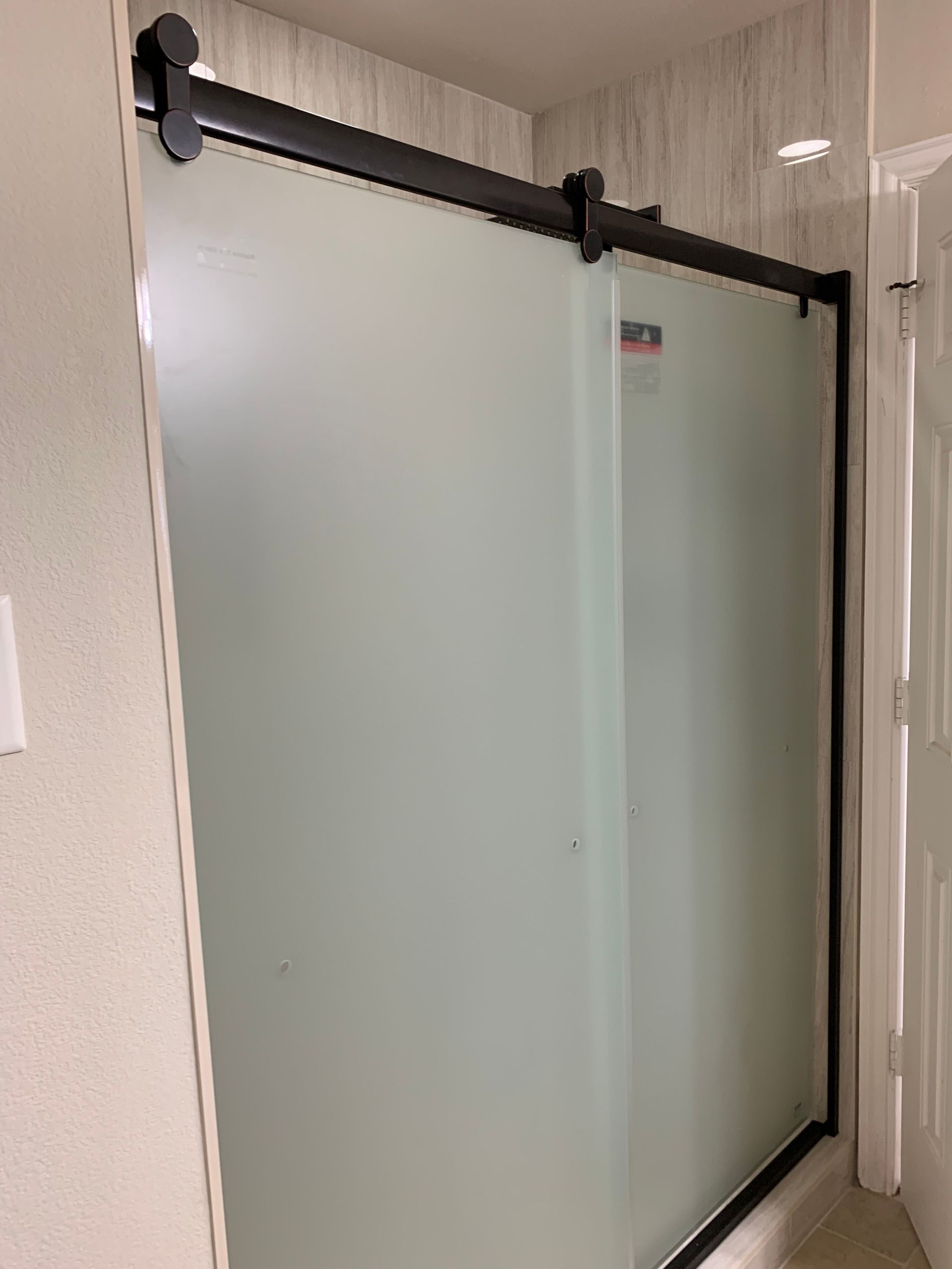 Glass shower enclosure with black framing in a bathroom