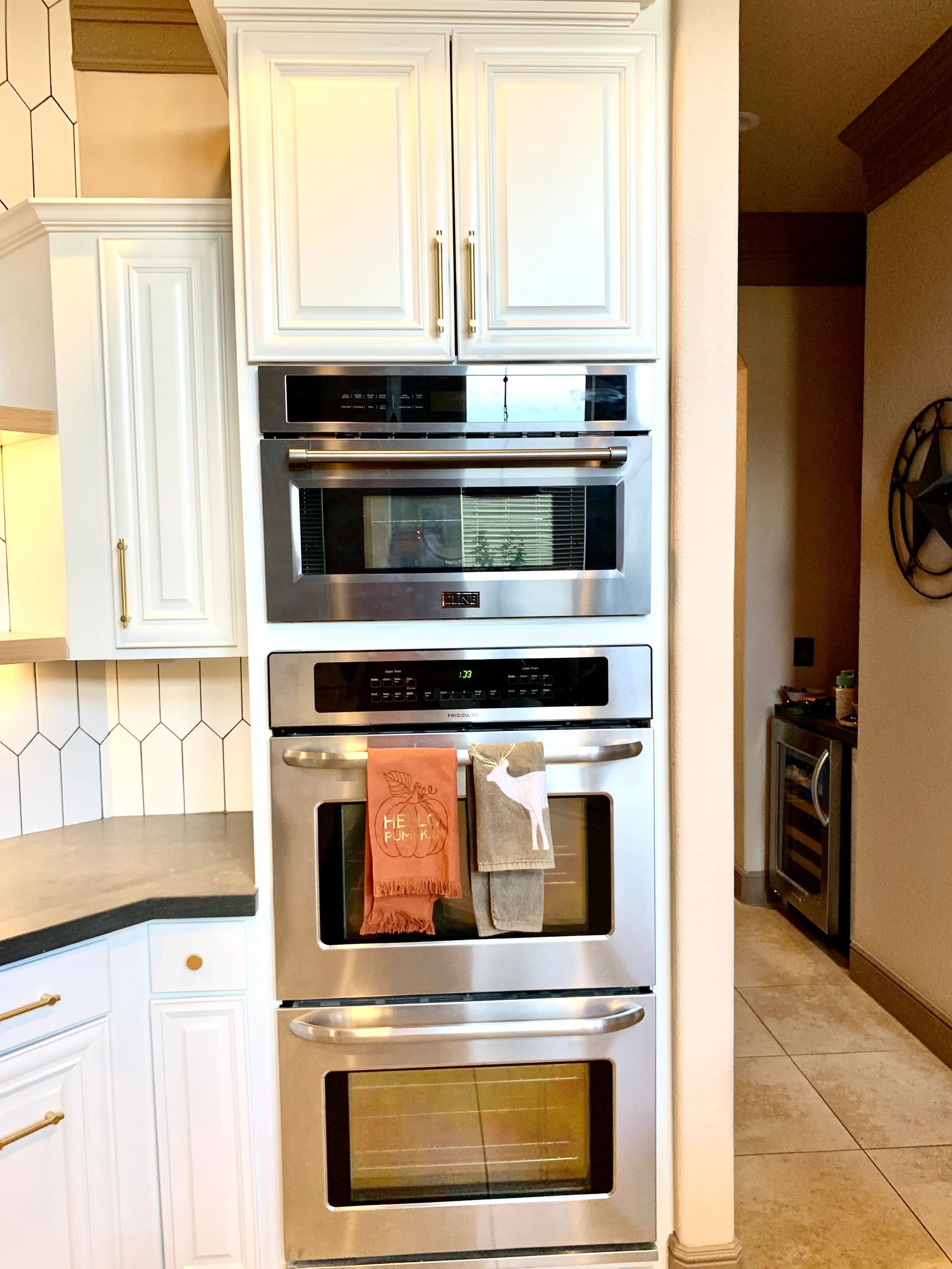 Built-in stainless steel double oven in a white kitchen cabinet wall