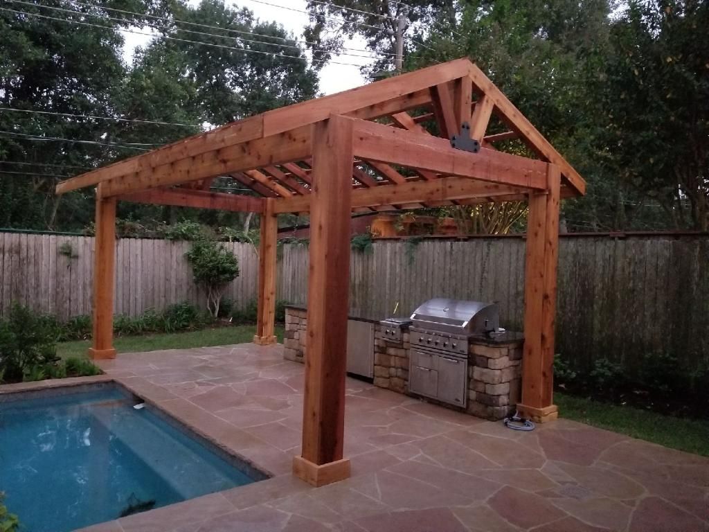 Wooden poolside pergola with exposed beams beside a backyard swimming pool and patio