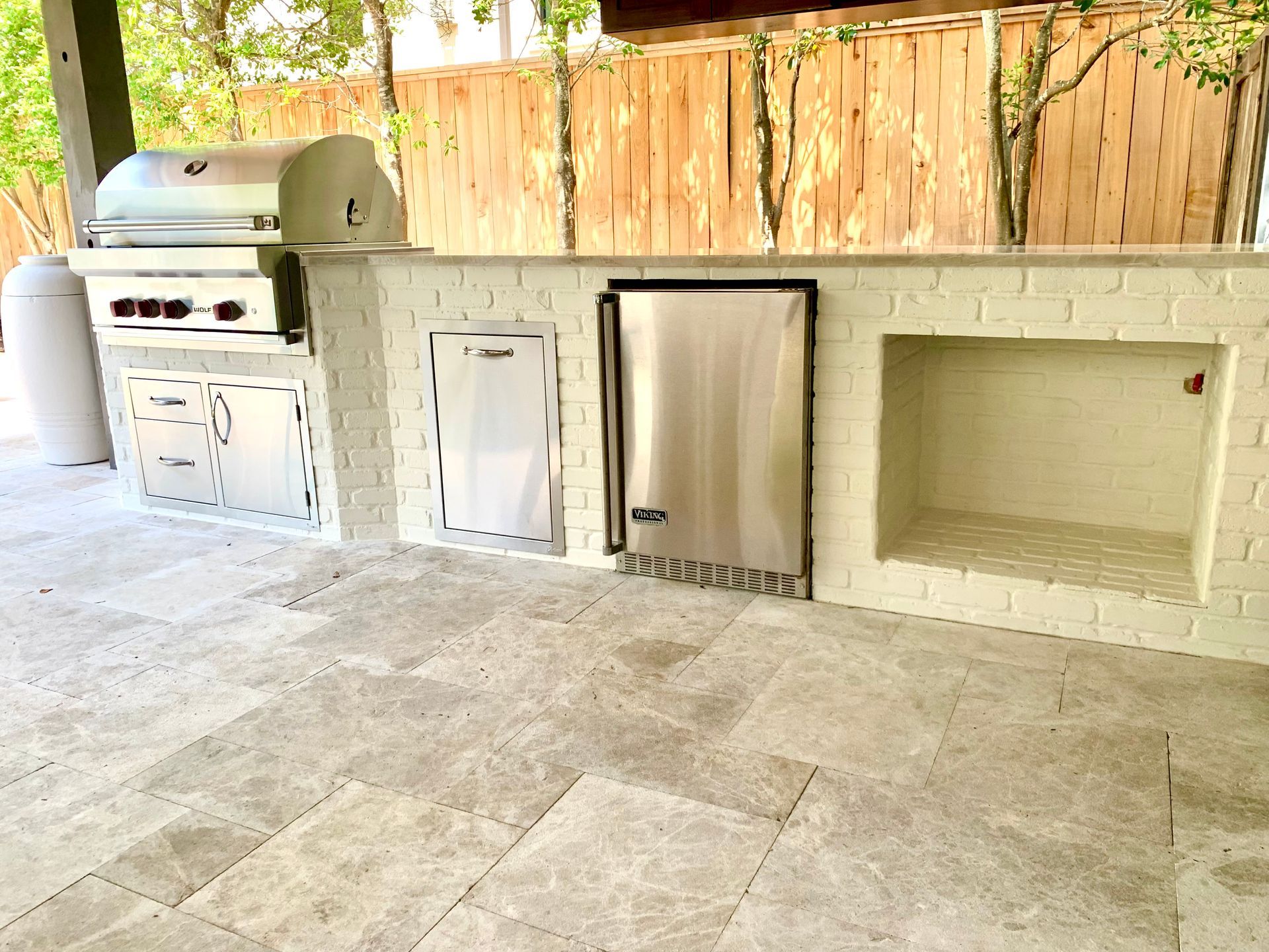 Outdoor patio with a built-in grill, storage cabinets, and a wall-mounted dog door