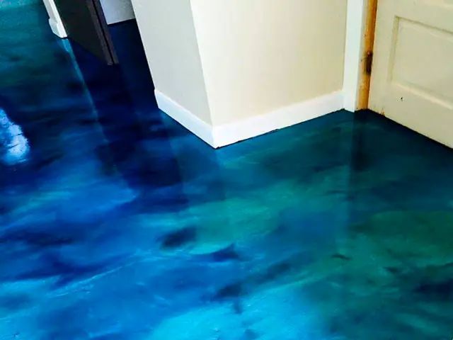 Blue and teal patterned floor with a white wall corner and a door in the background