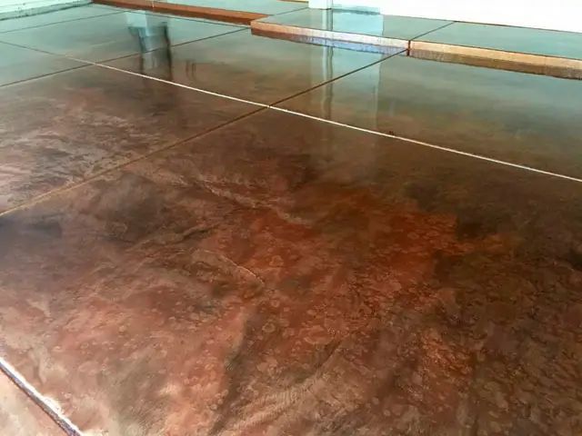 Close-up of a glossy brown tiled floor with reflections and a window ledge in the background