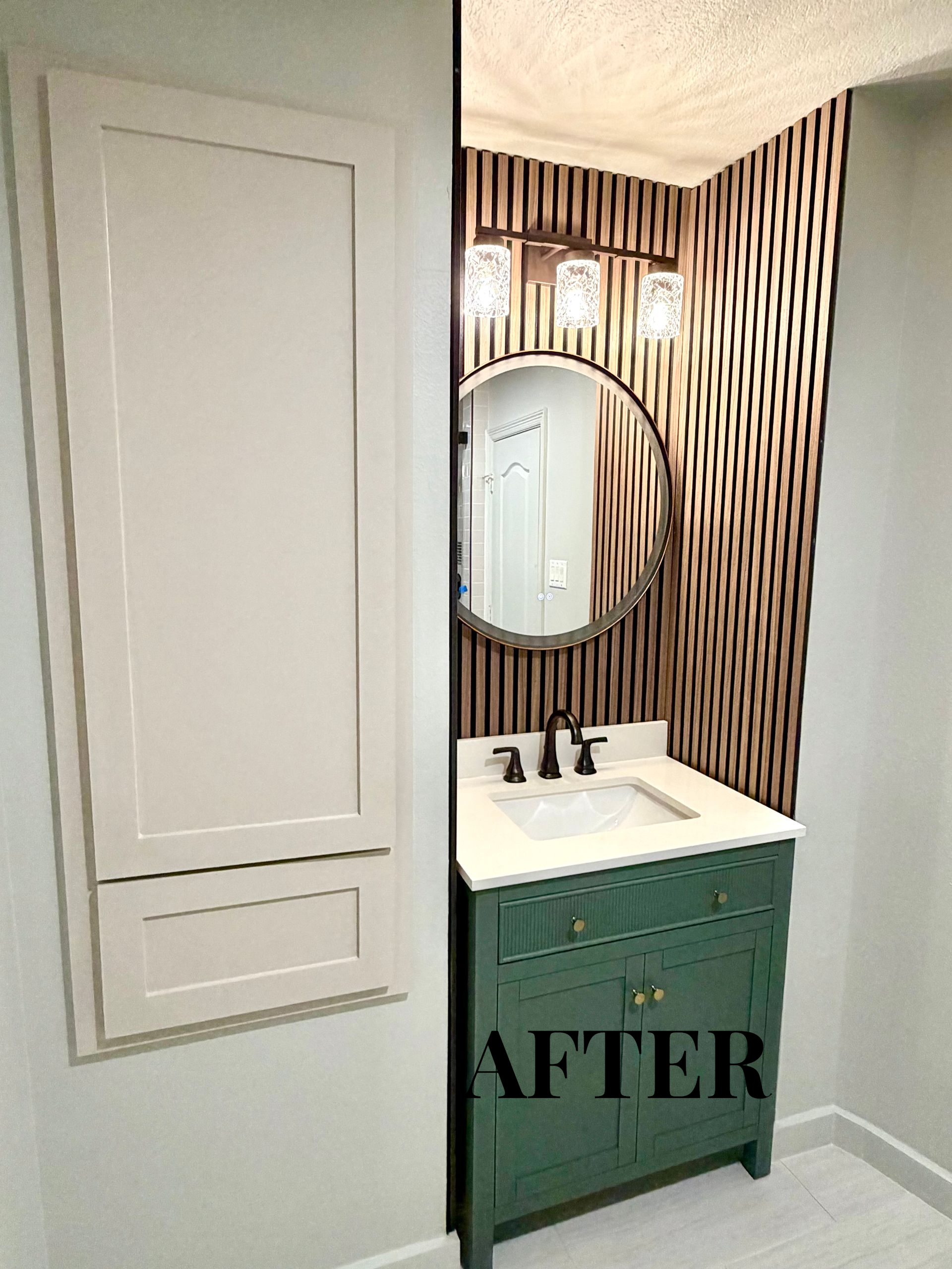 Small bathroom vanity with mirror and bold striped wallpaper, labeled “AFTER” on the cabinet.