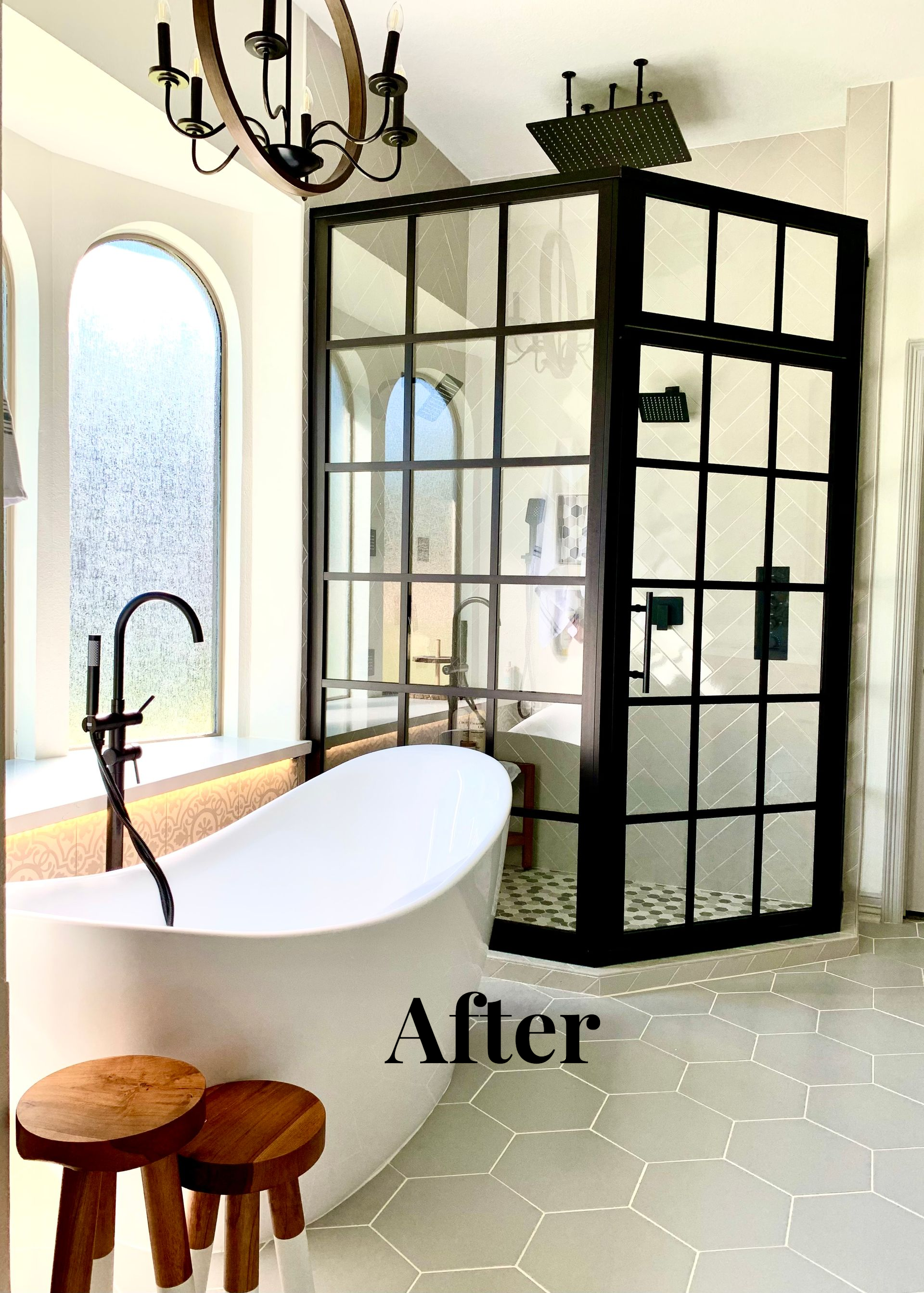 Modern bathroom with freestanding tub, black glass shower, and arched window and mirror.