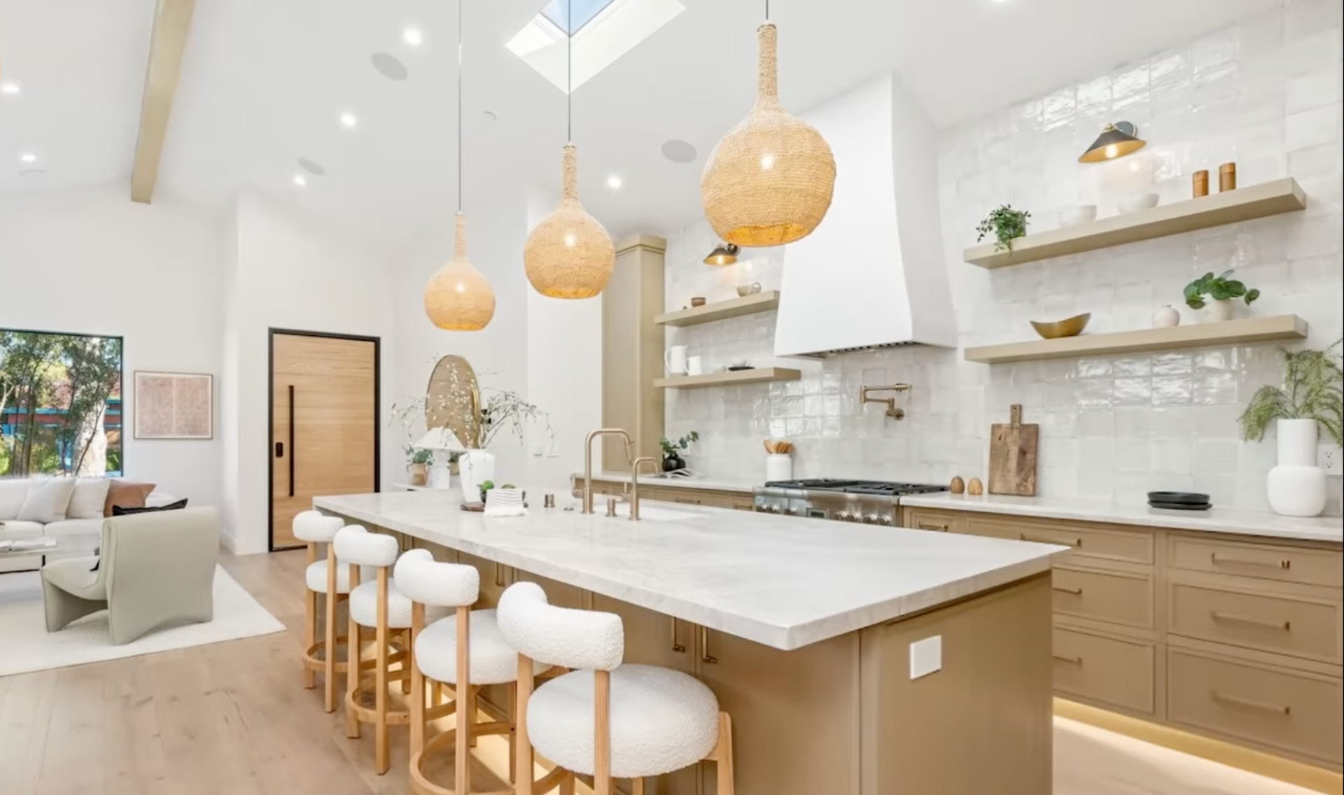 Bright modern kitchen with white cabinets, wood island, woven pendant lights, and barstools