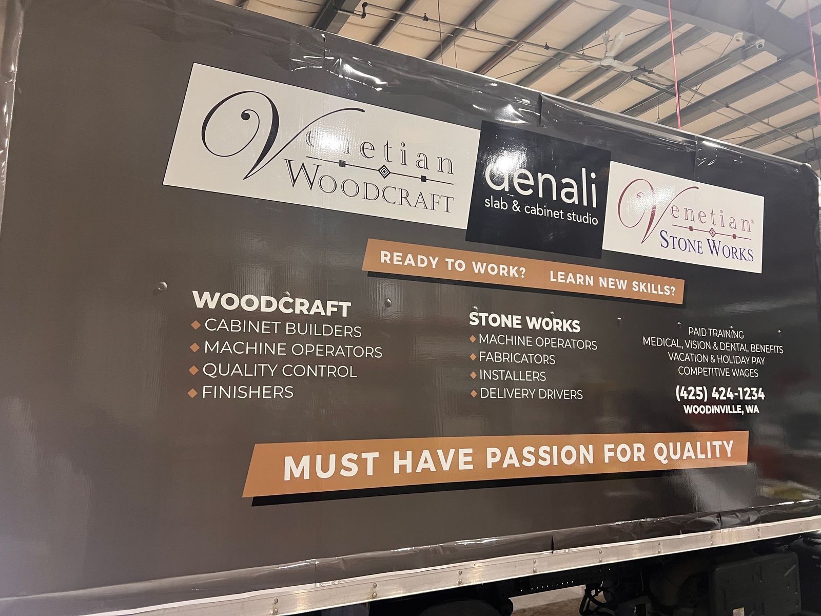 Woodcraft and stonework sign with “Ready to Work” and “Must Have Passion for Quality” on a black wall