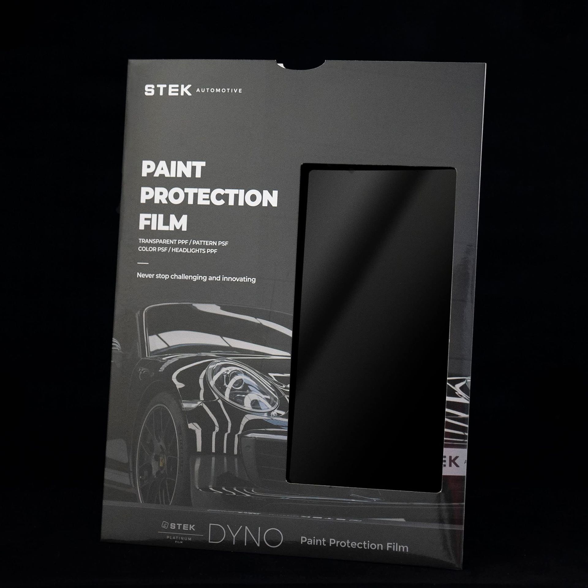 Black STEK paint protection film package with a car graphic and clear window display