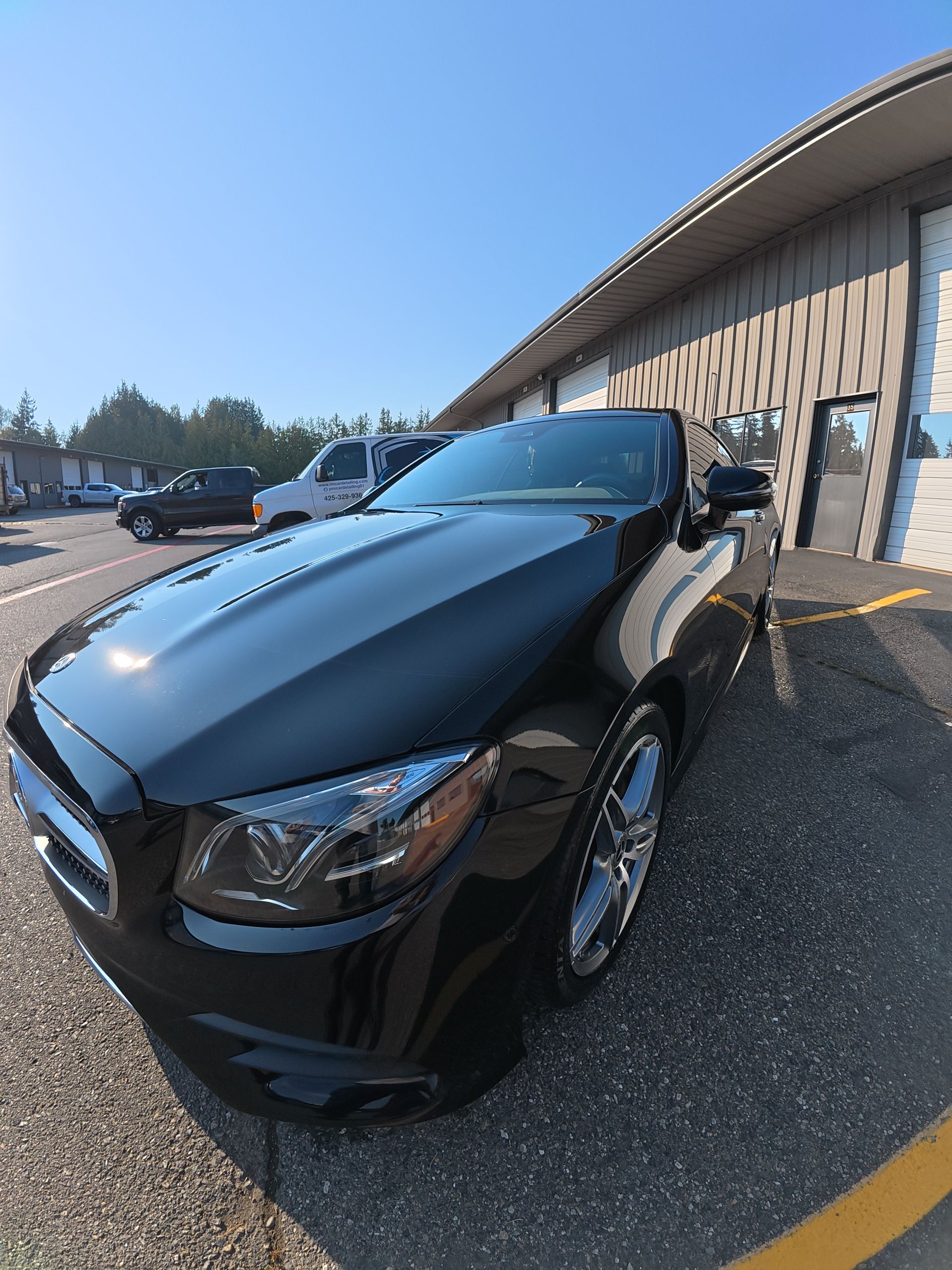 Black sports car parked outside a building on a sunny day