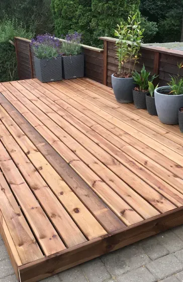 A wooden deck with potted plants on it.