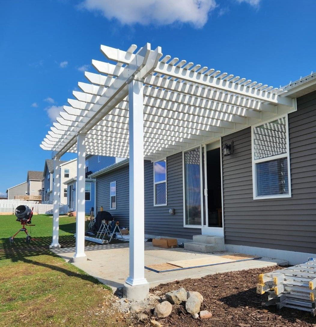 A black house with a wooden deck and a pergola.