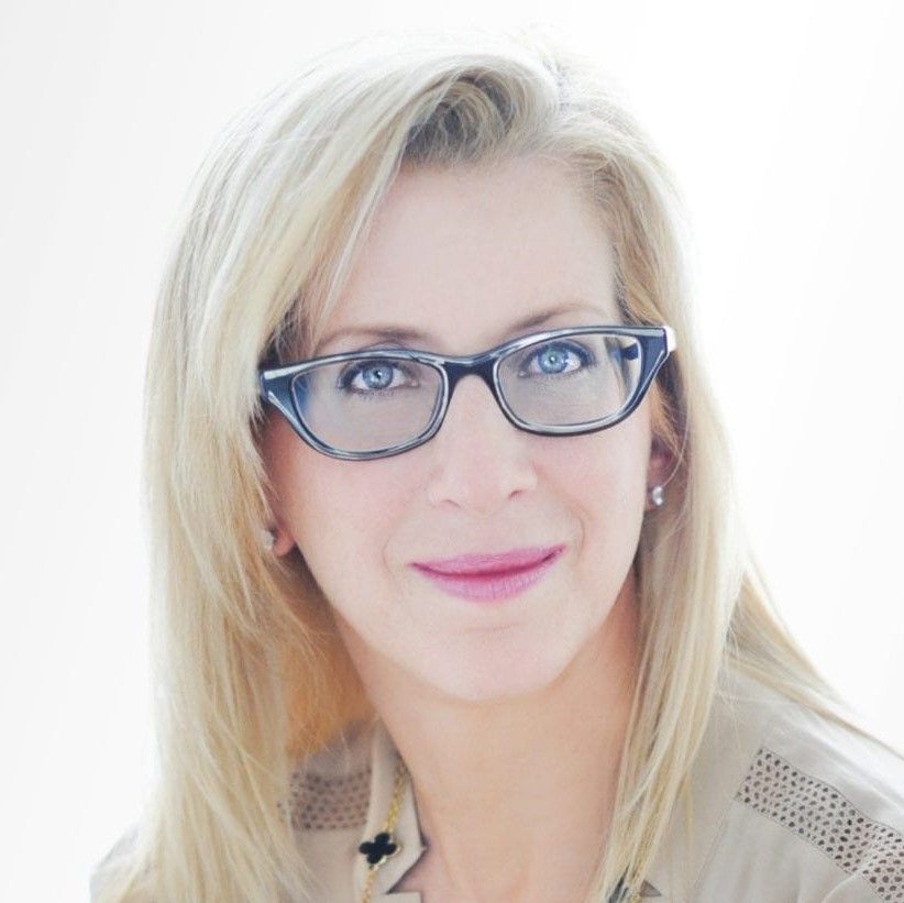 A woman wearing glasses is smiling for the camera.