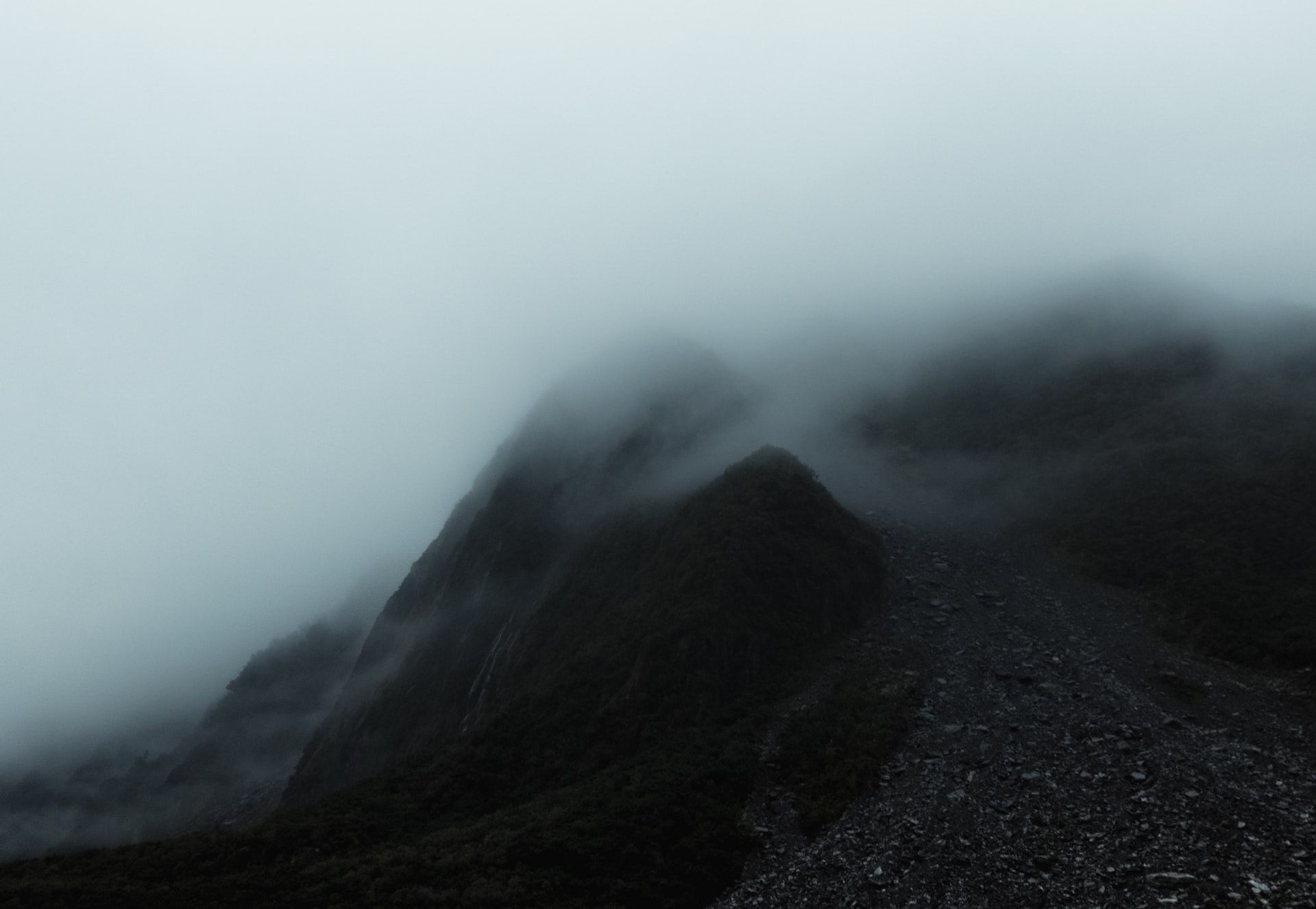 A mountain covered in fog and clouds on a foggy day.