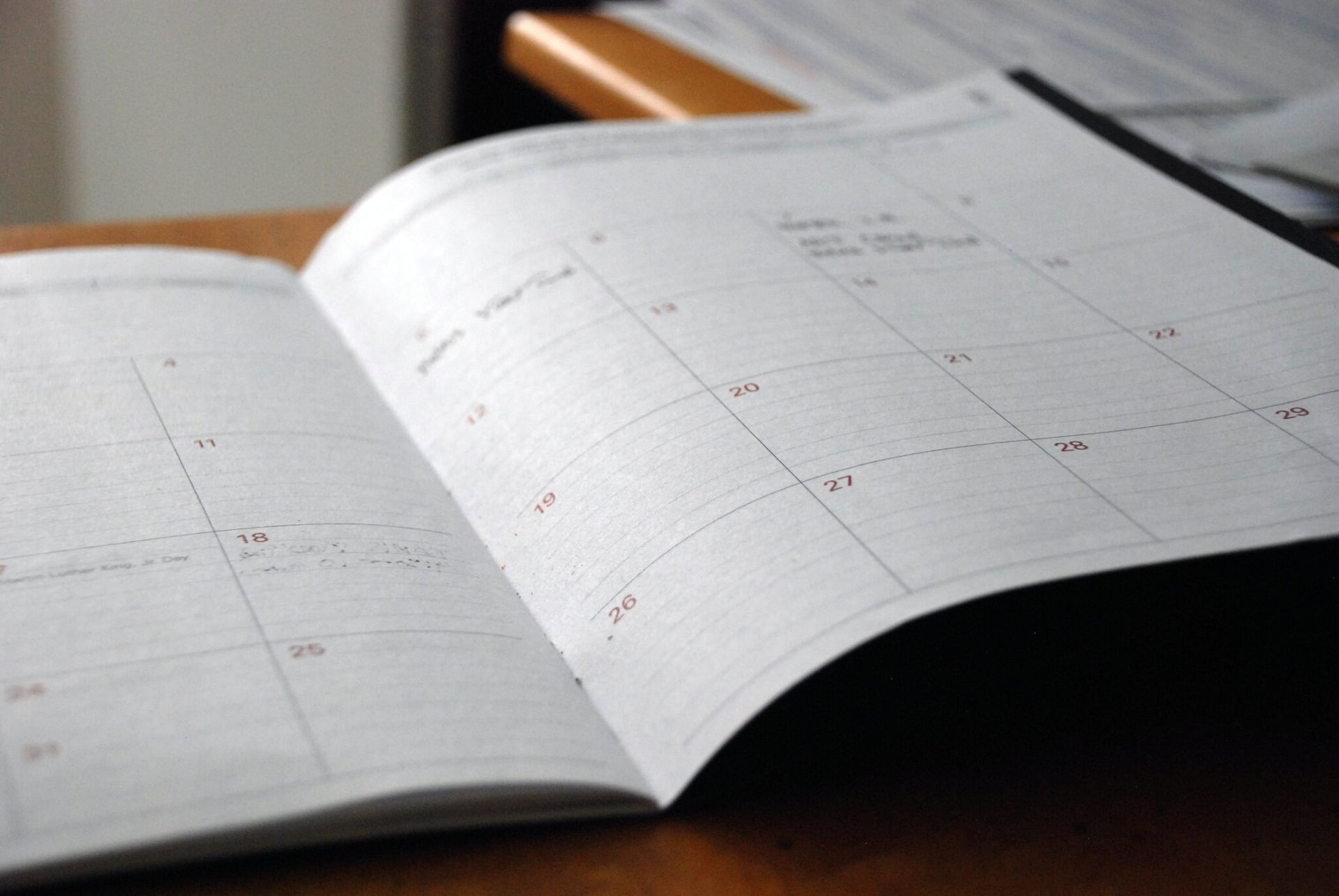 A calendar is open on a wooden table.
