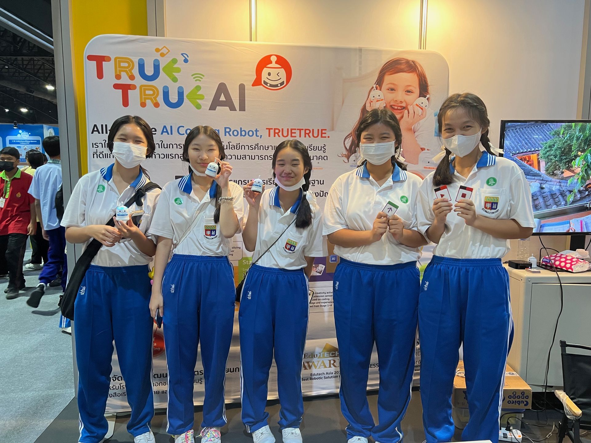 A group of young girls wearing masks are posing for a picture.