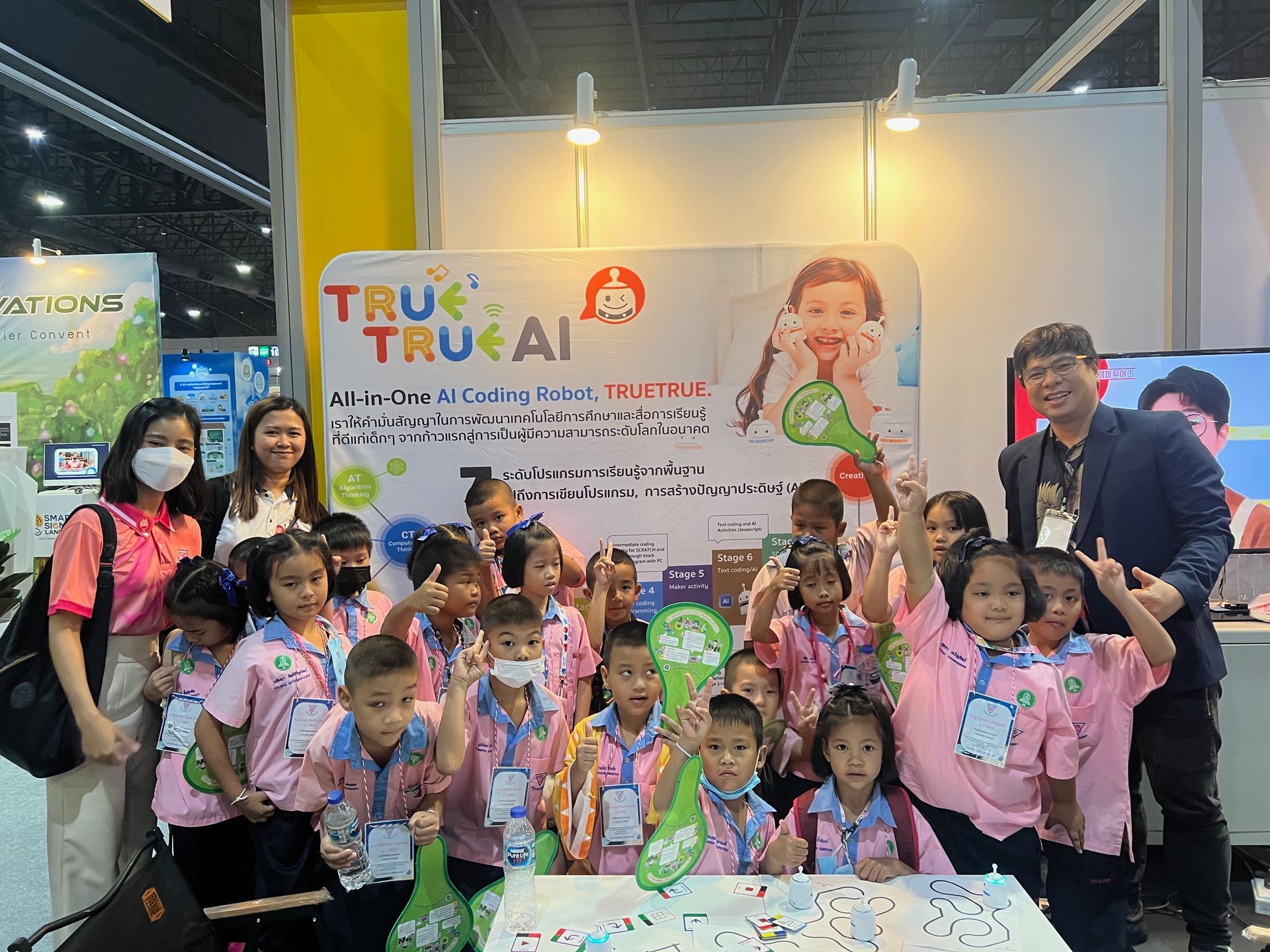 A group of children are posing for a picture at a convention.