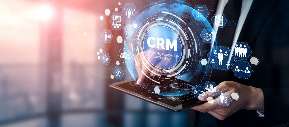 A man is holding a tablet with a screen that says crm on it.