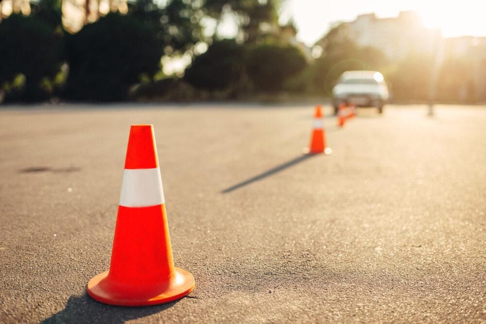 A Car is Driving Down a Road Next to a Traffic Cone  — Advanced Industry Training In South Townsville, QLD