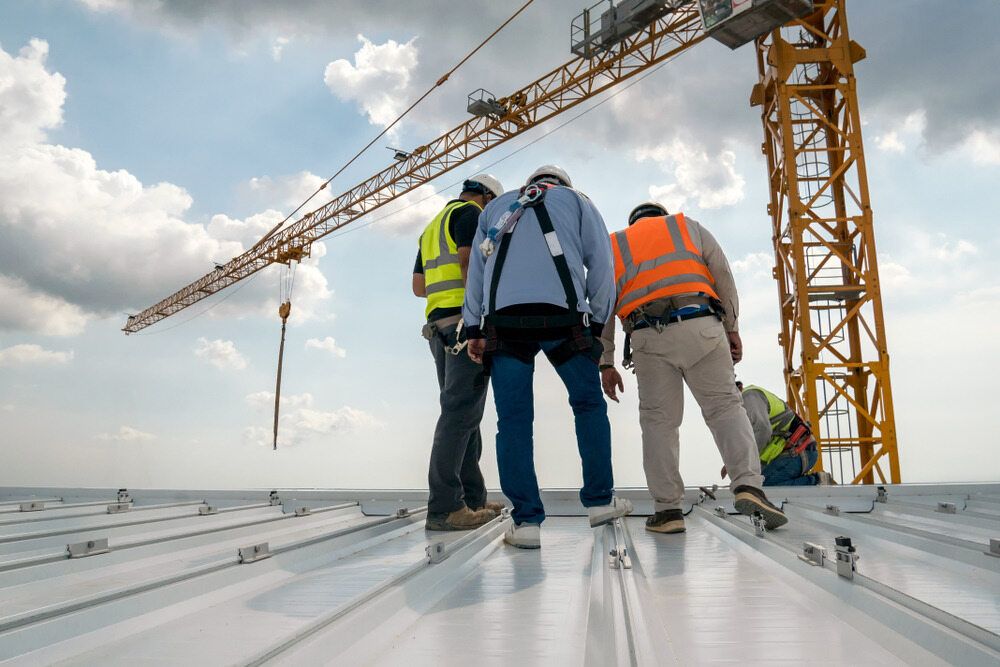 A Workers Are Standing on Top of a Roof — Advanced Industry Training In Cairns, QLD