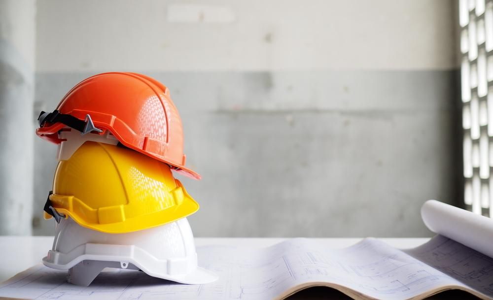 Three Hard Hats Are Stacked on Top of Each Other on a Table — Advanced Industry Training In Cairns, QLD