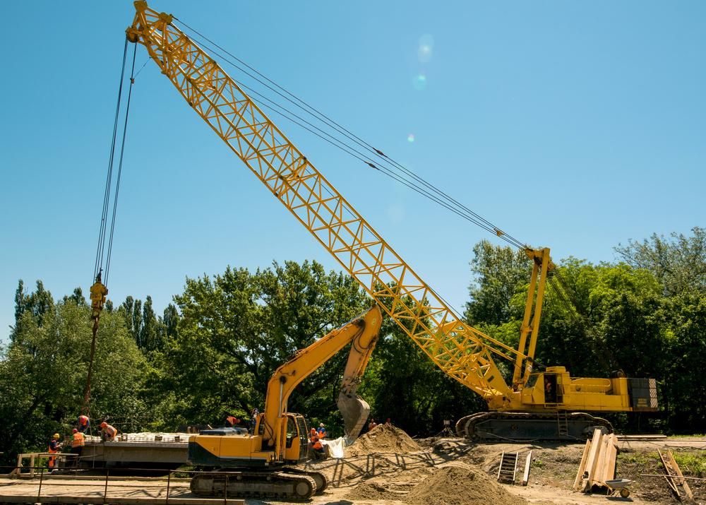 A Large Yellow Crane is Working on a Construction Site — Advanced Industry Training In Cairns, QLD