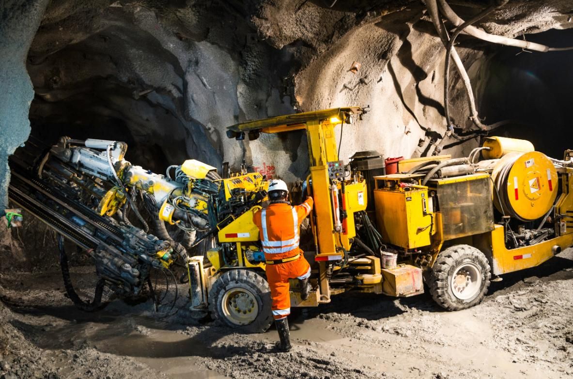 A Man is Standing Next to a Yellow Truck in a Tunnel — Advanced Industry Training In Cairns, QLD
