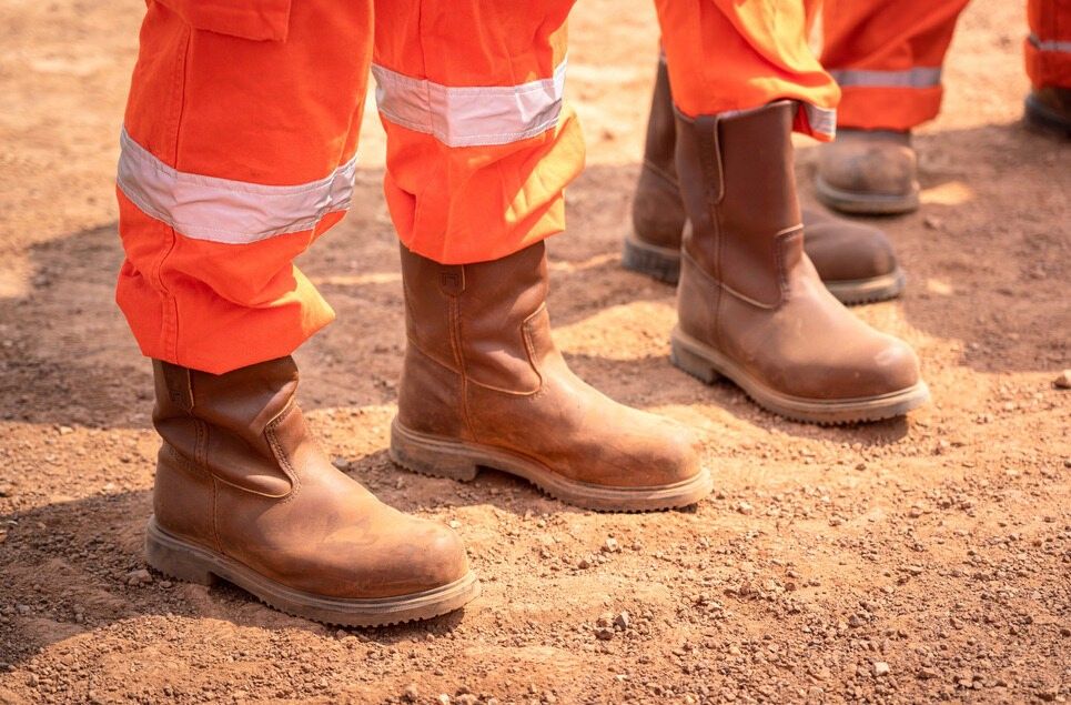 A Person Wearing Orange Pants and Brown Boots is Standing in the Dirt — Advanced Industry Training In South Townsville, QLD