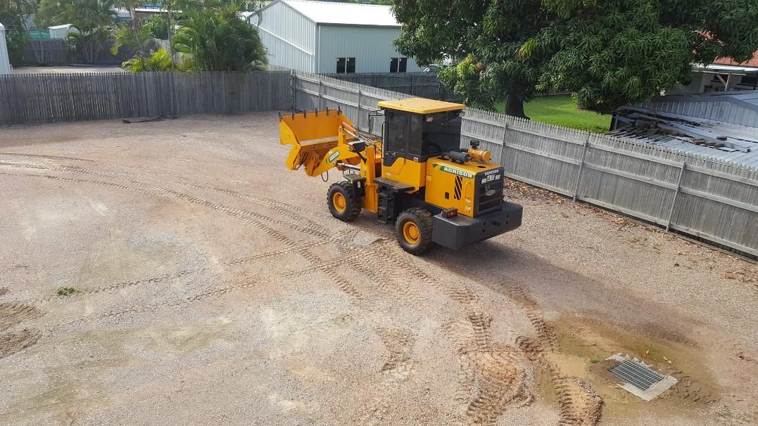 A Yellow Bulldozer is Driving Through a Dirt Field — Advanced Industry Training In South Townsville, QLD