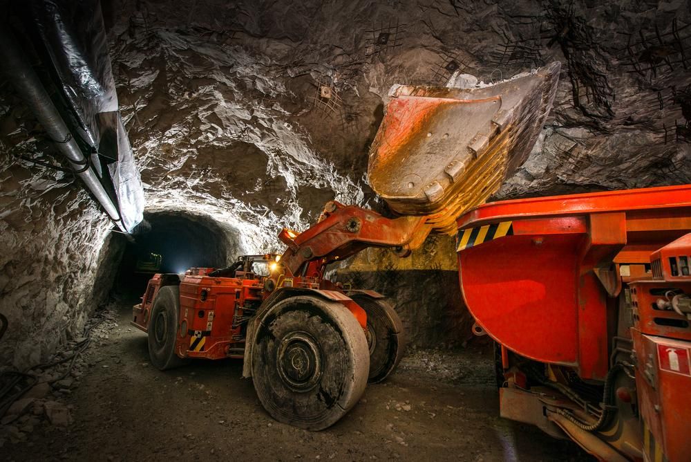 A Bulldozer is Loading Dirt Into a Dump Truck in a Mine — Advanced Industry Training In South Townsville, QLD
