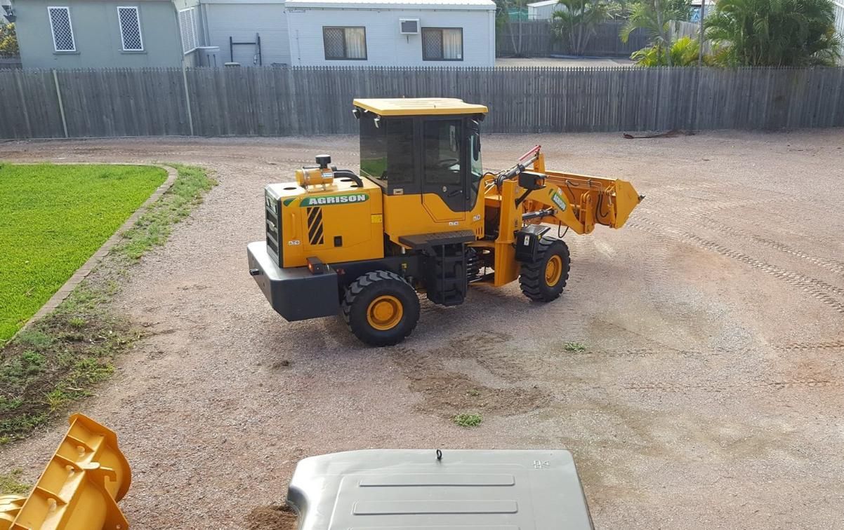 A Yellow Tractor is Parked in a Gravel Lot — Advanced Industry Training In Rockhampton, QLD