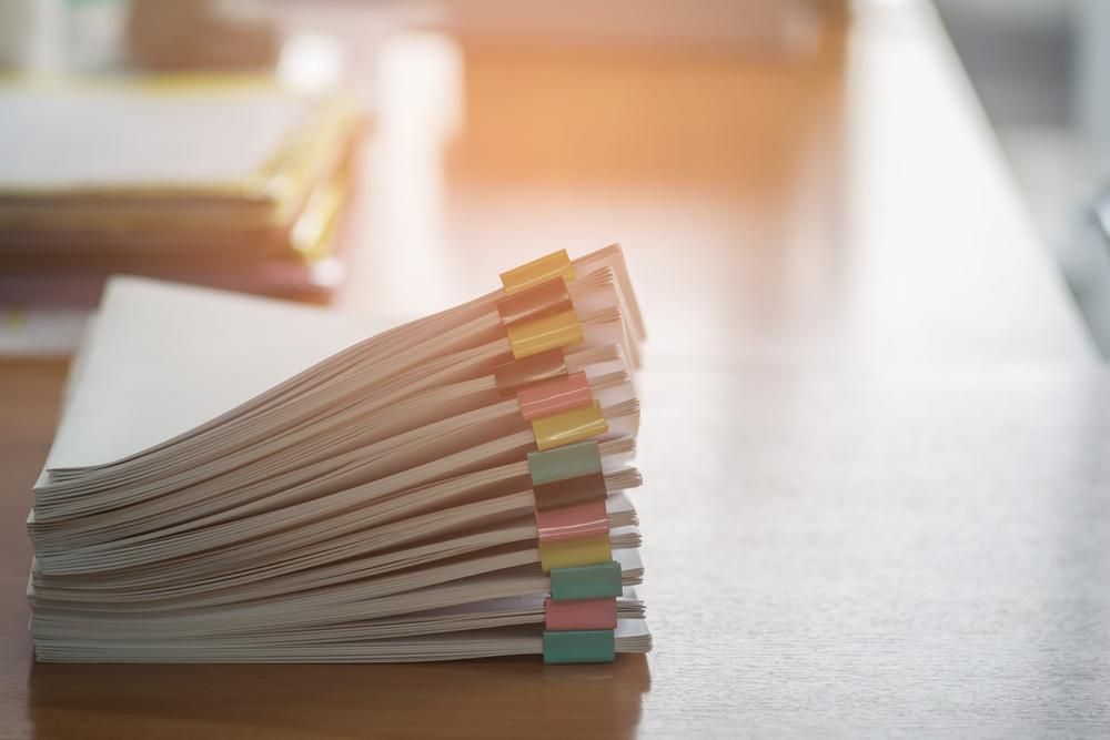 A Stack of Notebooks With Sticky Notes on a Wooden Table — Advanced Industry Training In Rockhampton, QLD