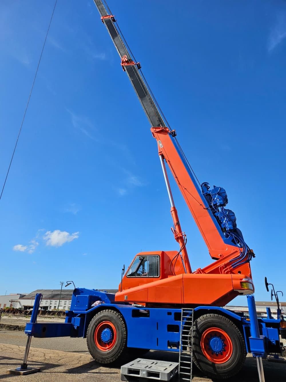 An Orange and Blue Crane is Parked on the Side of the Road — Advanced Industry Training In South Townsville, QLD