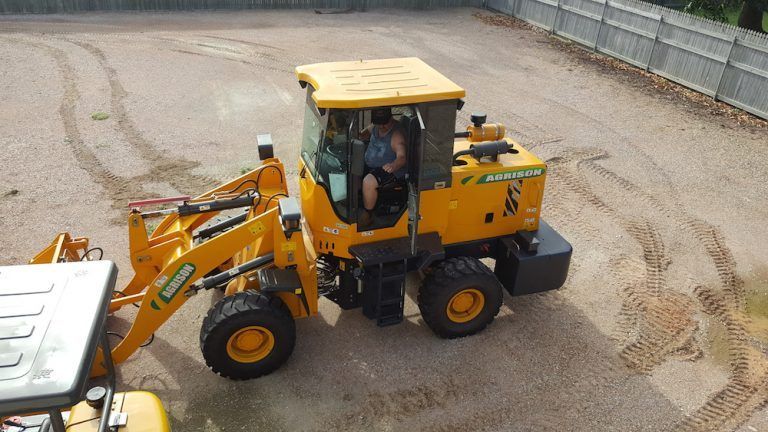 A Man is Driving a Yellow Tractor in a Dirt Field — Advanced Industry Training In South Townsville, QLD