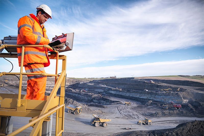 A Man is Standing on a Ladder Looking at a Laptop — Advanced Industry Training In South Townsville, QLD