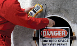 A Person is Holding a Device Next to a Danger Sign — Advanced Industry Training In South Townsville, QLD