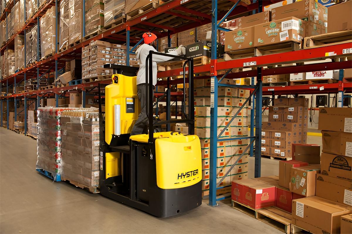 A Man is Driving a Yellow Forklift in a Warehouse — Advanced Industry Training In South Townsville, QLD