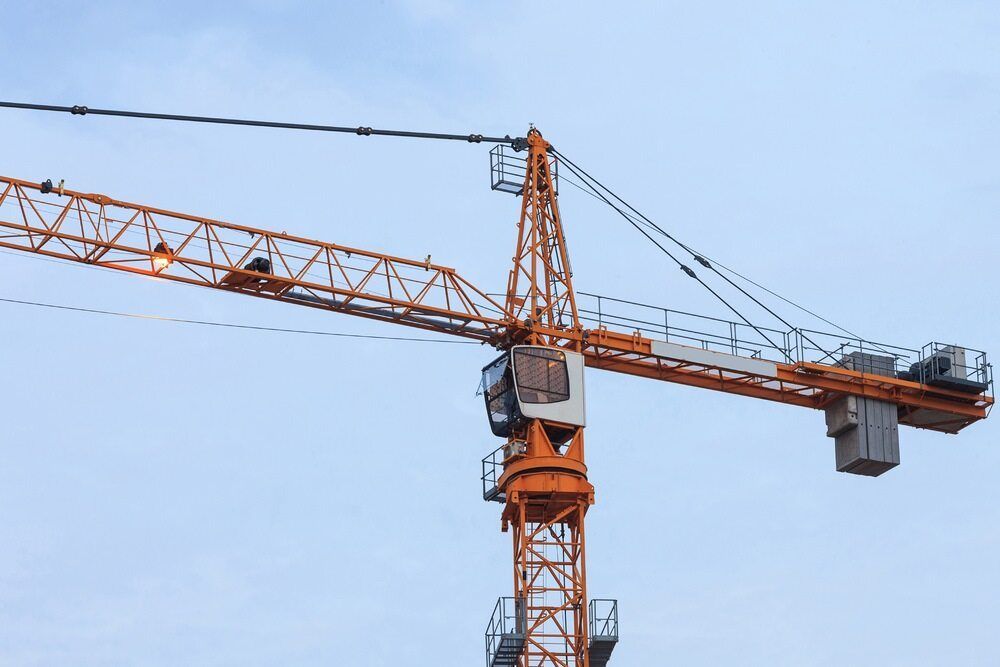 A Large Orange Construction Crane is Against a Blue Sky — Advanced Industry Training In South Townsville, QLD