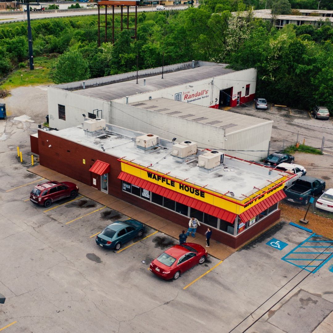 An aerial view of a waffle house with cars parked in front of it
