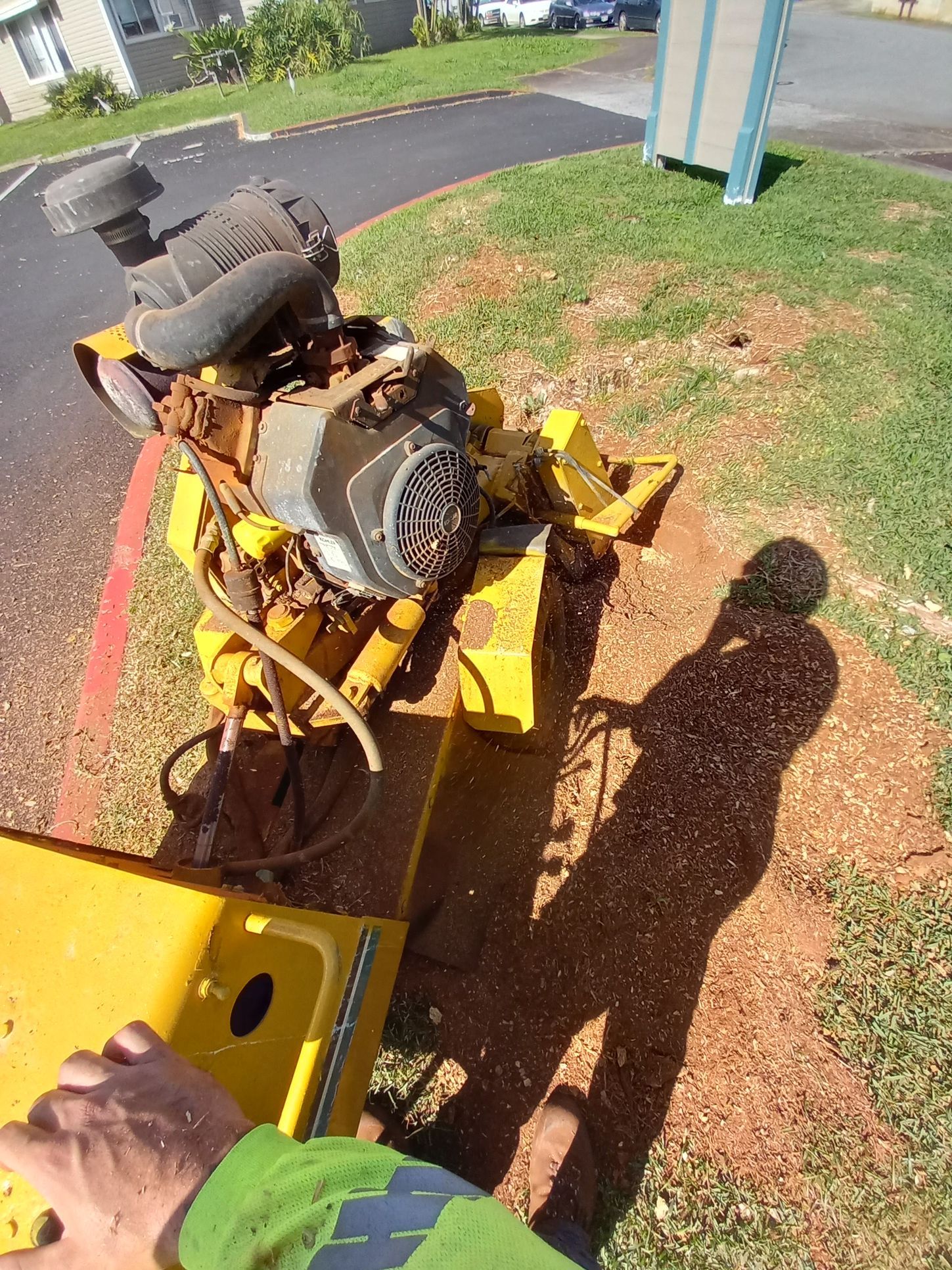 A yellow stump grinder grinding a tree stump into wood chips. A yellow stump grinder grinding a tree stump into wood chips.