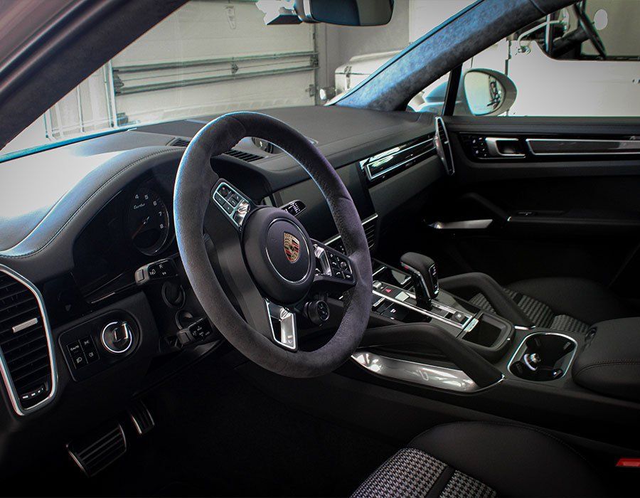 The inside of a porsche car with a steering wheel