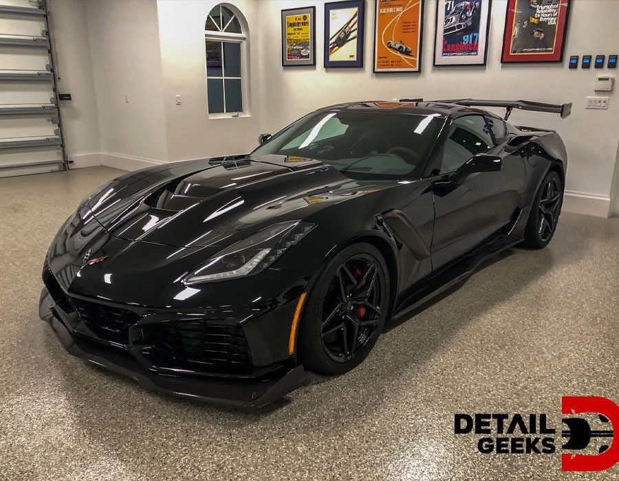 A black corvette zr1 is parked in a garage.