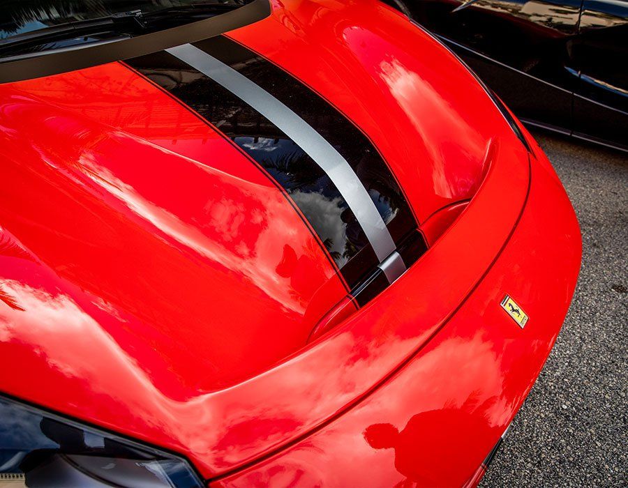 A close up of the hood of a red sports car