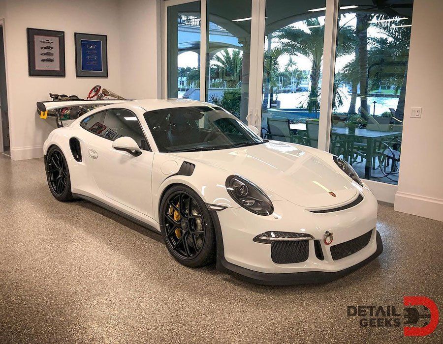 A white porsche 911 gt3 rs is parked in a garage.