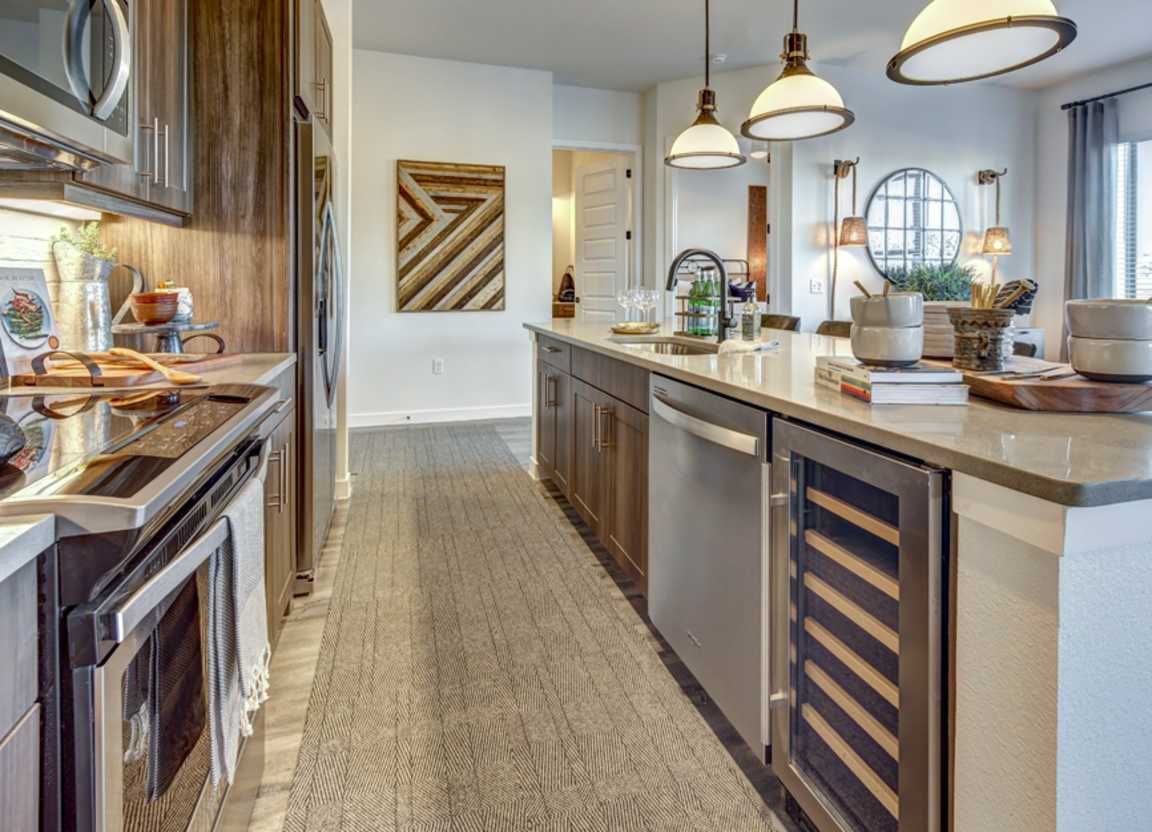 Modern kitchen with dark wood cabinets, stainless steel appliances, and a long island.
