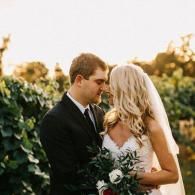 Bride and groom sharing a tender embrace in a garden at sunset