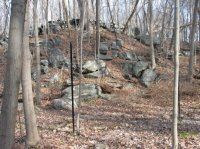 Wooded hillside with large exposed boulders and bare trees in late fall