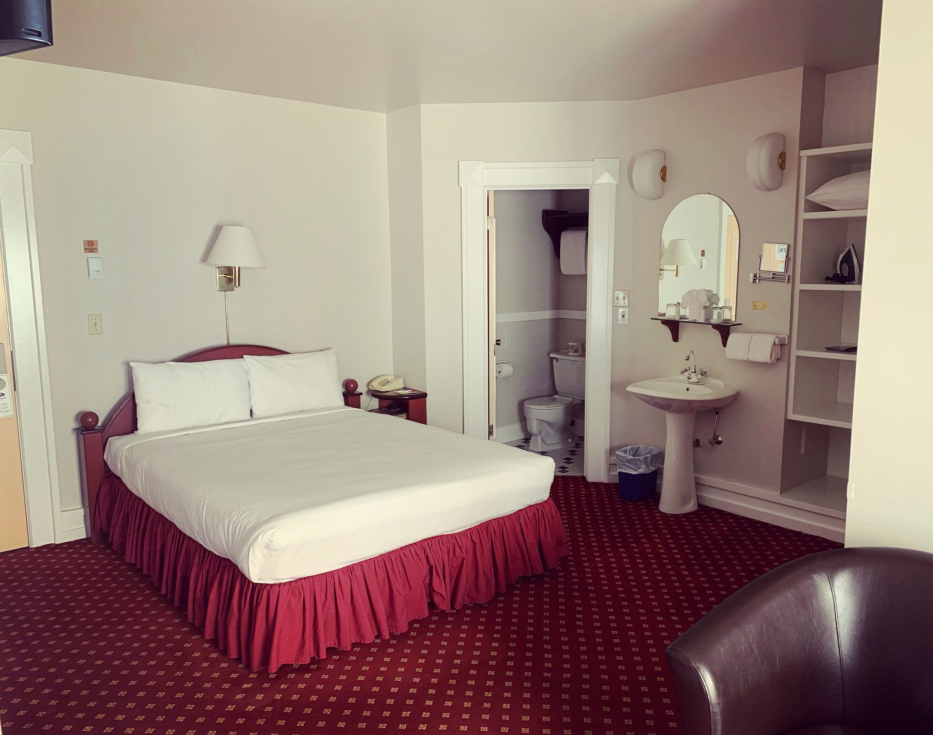 A hotel room with a king size bed and a sink