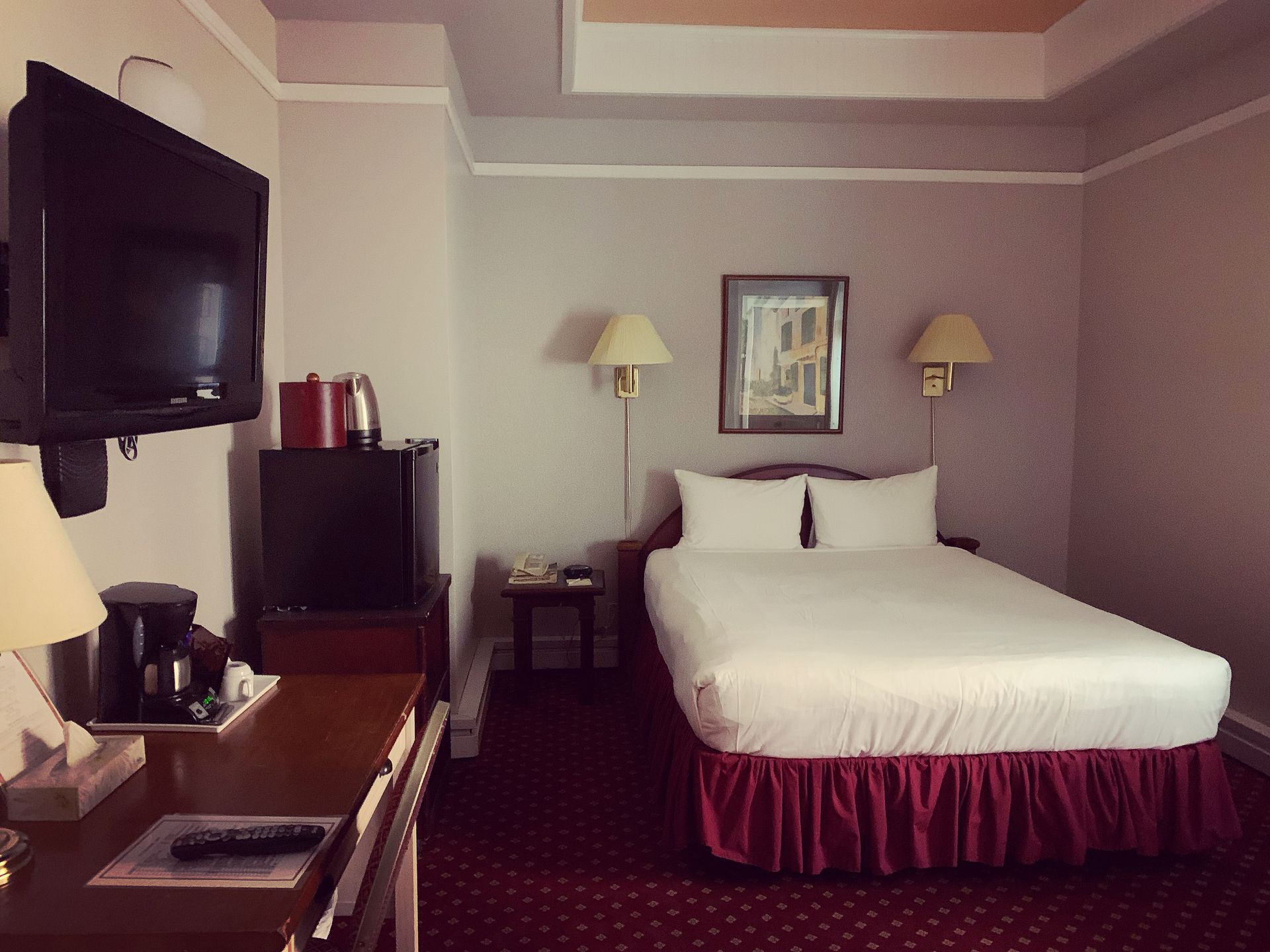 A hotel room with a king size bed and a flat screen tv