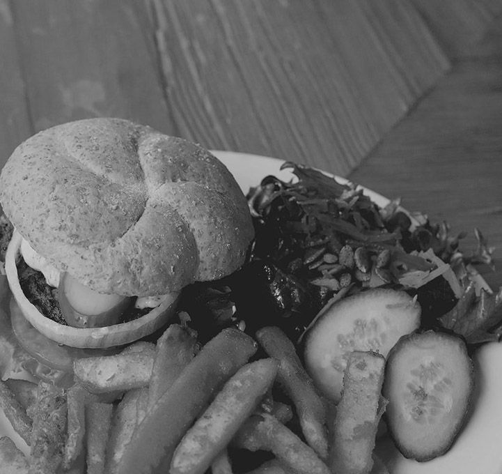 A black and white photo of a hamburger and french fries